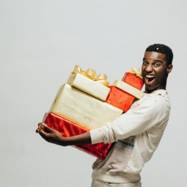 Excited man holding large gifts.